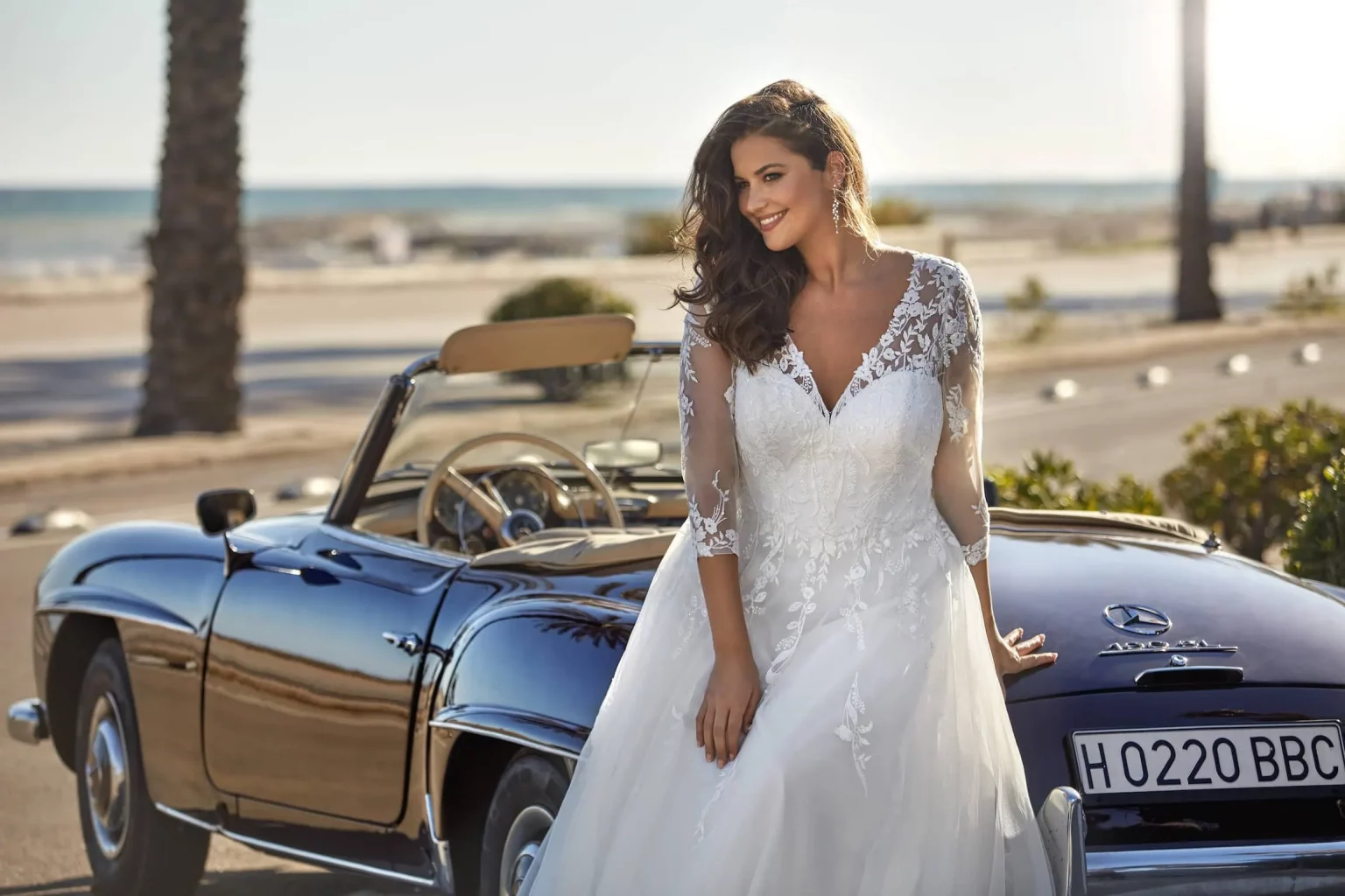 Trägerlos-Ballkleid Brautkleid mit Herzausschnitt, Spitzenoberteil und Schleier im Sonnenuntergang am Meer – Modell 8273, DIVAS Hochzeitshaus Singen