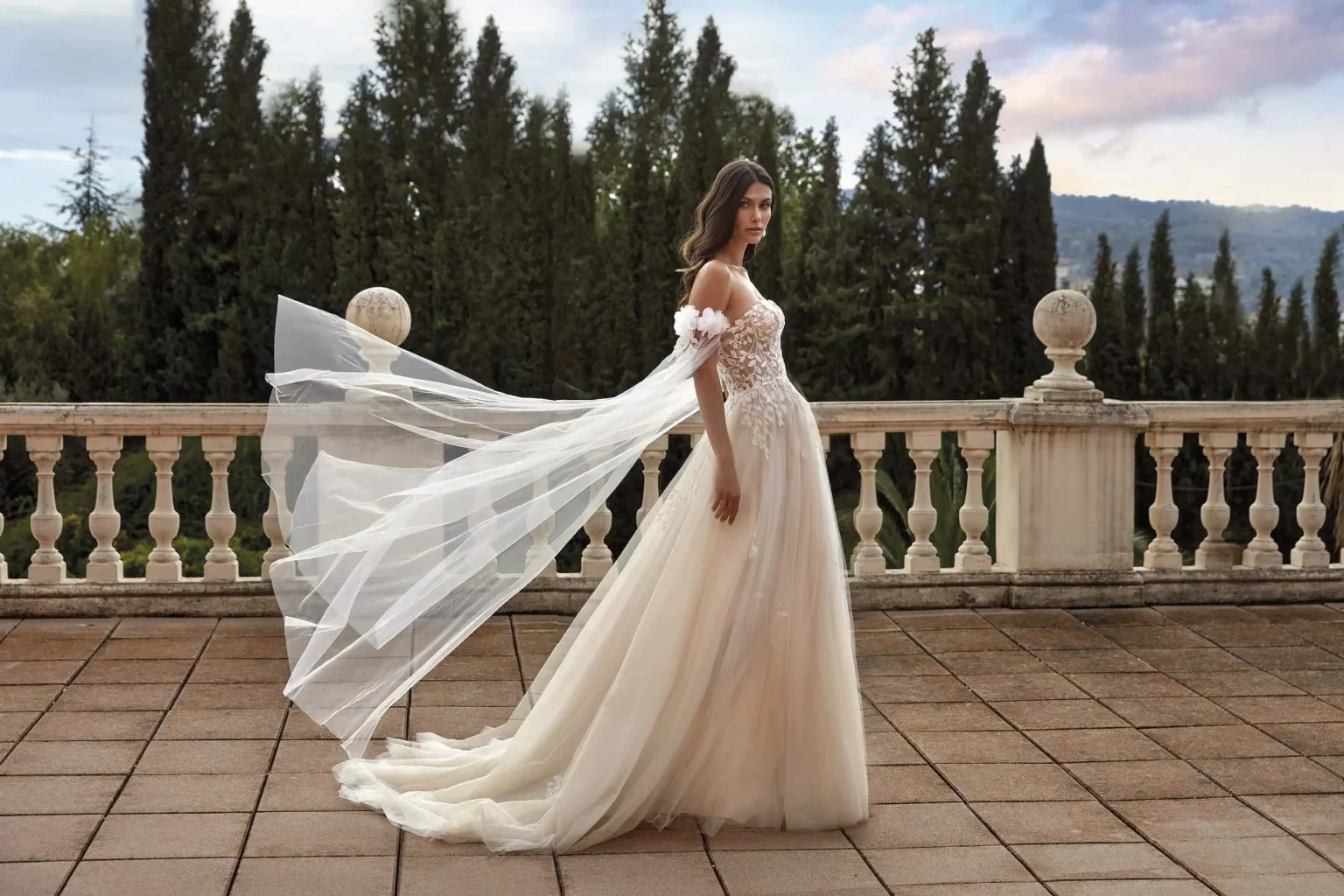 Brautkleid in großen Größen aus Chiffon mit tiefem V-Ausschnitt und flatternden Ärmeln vor Meereshintergrund, Modell 35019U – DIVAS Hochzeitshaus Singen